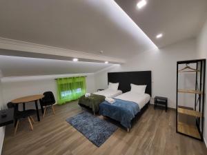 a bedroom with a bed and a table and a green window at Casa Borges in Charneca