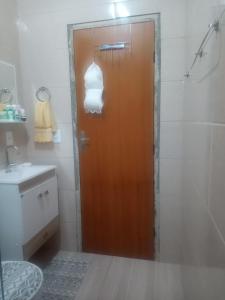 uma casa de banho com uma porta castanha e um lavatório em Nosso Pedacinho em Abraão