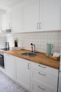 a kitchen with white cabinets and a sink at Appartement Nordlicht in Eutin