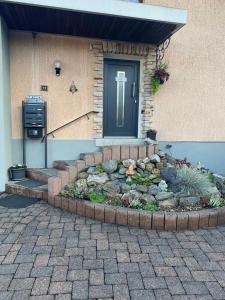 une porte d'entrée d'une maison avec un jardin à l'avant dans l'établissement Beti Apartment, à Nentershausen