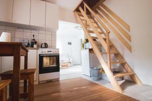 a kitchen with a wooden staircase leading up to a kitchen at Rozetta Vendégház in Kismaros