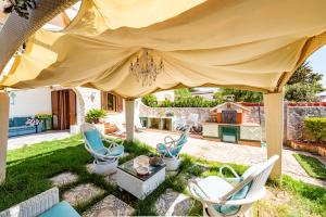 een patio met stoelen en een tafel onder een grote tent bij Extravacanza Safari in Selva di Fasano