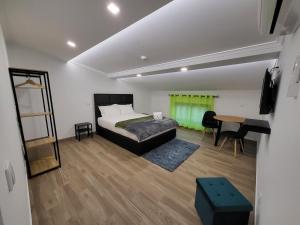 a bedroom with a bed and a table and a desk at Casa Borges in Charneca