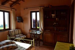 a bedroom with a bed and a chair and a table at Le Macchie in Baschi