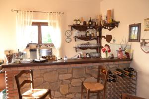 a kitchen with a stone fireplace with two chairs at Le Macchie in Baschi