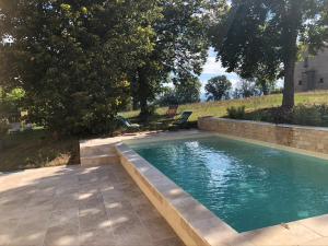a swimming pool in a yard with two chairs at Le gîte du Trianon d'Yss in Issoire
