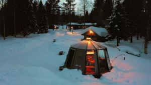 einen Pavillon mit Licht im Schnee in der Unterkunft Ollero Eco Lodge (including a glass igloo) in Rovaniemi