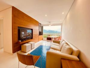 ein Wohnzimmer mit Couch und Flachbildfernseher in der Unterkunft Vista Mágica em Camburizinho D in São Sebastião