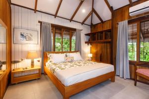 1 dormitorio con 1 cama en una habitación con ventanas en Kalawala en Puerto Viejo