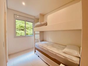 ein Schlafzimmer mit Etagenbett und Fenster in der Unterkunft Vista Mágica em Camburizinho D in São Sebastião + 51 Fotos