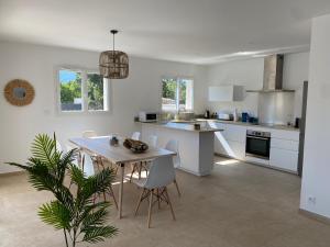 a kitchen and dining room with a table and chairs at Villa Camille in Prunelli-di-Fiumorbo