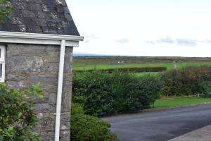 a house with a view of a road and a field at Aran View Holiday Homes Doolin - The Courtyard House - Sleeps 9 in Knockfin Cross Roads +1 photo