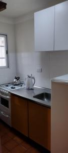 a kitchen with a sink and a tea kettle on the counter at Apartamento Libra 6 in Villa Gesell