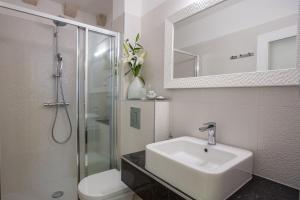 a bathroom with a sink and a toilet and a mirror at Villa Flores Room in Dubrovnik