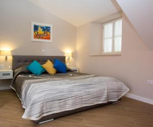 a bedroom with a bed with blue and yellow pillows at Villa Flores Room in Dubrovnik