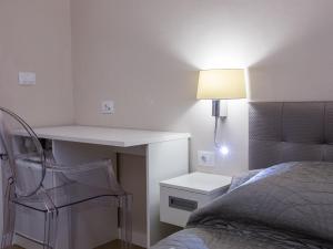 a bedroom with a bed and a desk and a lamp at Villa Flores Room in Dubrovnik