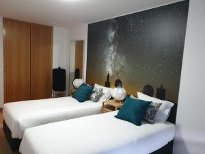 Duas camas num quarto com uma parede estrelada em Altavista Penthouse T2 na Covilh�