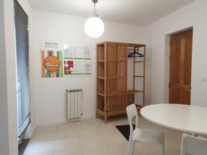 uma sala de jantar com uma mesa e cadeiras brancas em Altavista Penthouse T2 na Covilh�