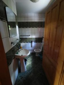 a bathroom with a sink and a toilet at Cabana Kristof Kulcsosház in Borzont