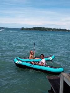
two people on a small boat in the water at Faro del Colibri in Bocas del Toro
