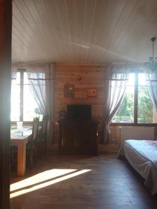 a bedroom with a bed and a table and windows at Chouette in Annecy