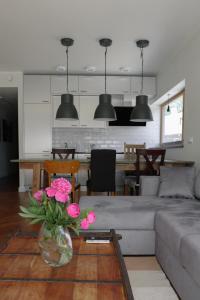 ein Wohnzimmer mit einem Sofa und einem Tisch mit rosa Blumen in der Unterkunft Tolli korter in Kuressaare