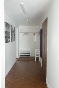 a hallway with white walls and a wooden door at Tolli korter in Kuressaare