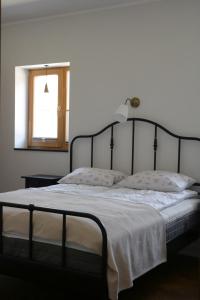 ein Schlafzimmer mit einem Bett mit einem schwarzen Rahmen und einem Fenster in der Unterkunft Tolli korter in Kuressaare