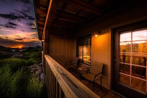 a porch of a house with two chairs and a sunset at Tombstone Miners Cabins in Tombstone