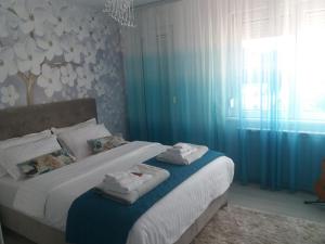 a bedroom with a bed with towels on it at Apartman Akik 2 in Šabac