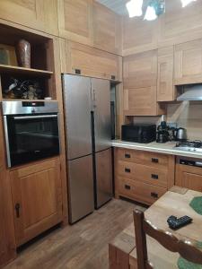 a kitchen with a stainless steel refrigerator and wooden cabinets at Chouette in Annecy +5 photos