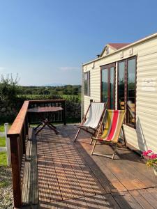 una terraza con mesa y sillas junto a un edificio en Farm stay property Pets and families welcome en Rossnowlagh