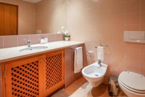 La salle de bains est pourvue d'un lavabo et de toilettes. dans l'établissement Nortada Suite Beach Apartment T2, à Lagos