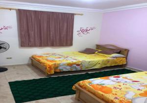 een slaapkamer met 2 bedden en een raam bij AC, Wi-Fi Shahrazad Beach Apartment-2 in Alexandrië