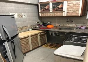 een keuken met een koelkast en een wastafel bij AC, Wi-Fi Shahrazad Beach Apartment-2 in Alexandrië