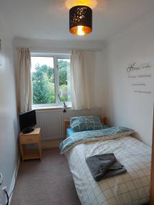 a small bedroom with a bed and a window at Spacious and Serene Stay near Milton Keynes centre in Willen