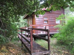 een houten hut met een houten hek ervoor bij Hospedaje Las Gardenias in Lago Puelo