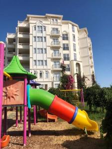 um parque infantil com um escorrega em frente a um edifício em Watercastle Suites em Erdemli