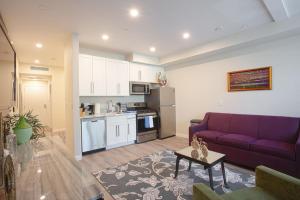 a living room with a purple couch and a kitchen at 3 Floor TownHouse Next to Downtown Max 12 sleepers in San Diego