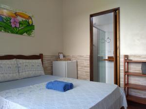 a bedroom with a bed with a blue pillow on it at Pousada Marimbá in Trindade