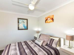 a bedroom with a bed and a ceiling fan at Noraville Summer House in Norah
