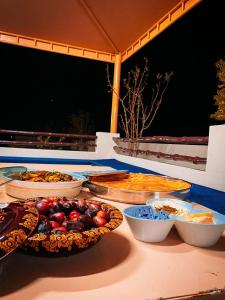 a table with several pies and bowls of food at Desert Dune Farmhouse - By Seven Elements in Ras al Khaimah