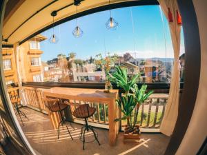 a balcony with a table and chairs and a large window at Apto Panorâmico 3 quadras da Rua Coberta in Gramado