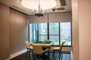 a dining room with a ping pong table and chairs at OHYA Chain Boutique Motel Taoyuan in Taoyuan