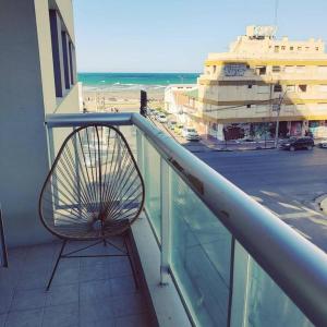 una sedia su un balcone con vista sulla spiaggia di Luz de Madryn a Puerto Madryn
