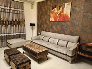 a living room with a couch and a painting on the wall at Here Homestay Guoguang Branch in Ruisui