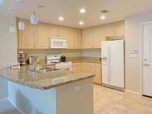 a kitchen with a sink and a white refrigerator at Irvine 2Bedroom 2 Bathroom Apartment with Kitchen Pool gym in Irvine +1 photo