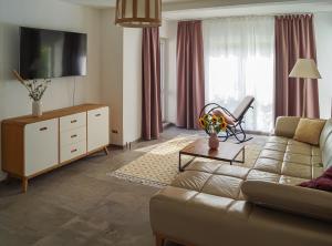 a living room with a couch and a tv at Ferien unnern Appelboom (80m2 Wohnung mit großem Garten) in Groß Kordshagen