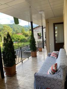 a porch with potted plants and a couch on a balcony at Warm Flat in Gonio