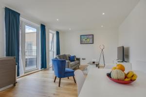 a living room with a table with a bowl of fruit at Modern & Spacious Studio & One Bedroom Apartments in Heathrow in Hounslow
